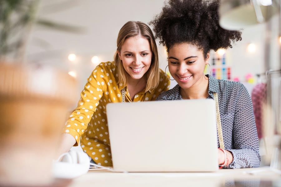 Two professionals reviewing candidate insight on a laptop